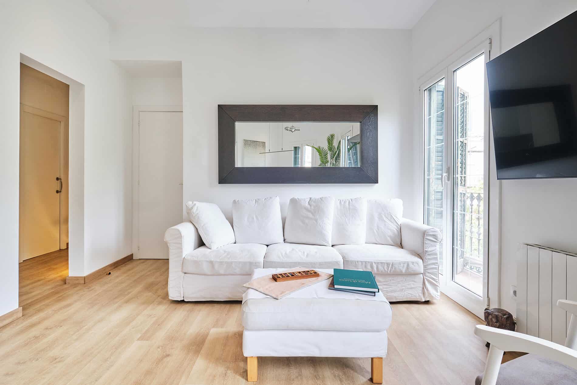Barcelona roof studio - first floor, living room area with a white couch and ottoman, designed by Beatrice Leupold Barcelona roof studio - first floor, living room area with a white couch and ottoman, designed by Beatrice Leupold